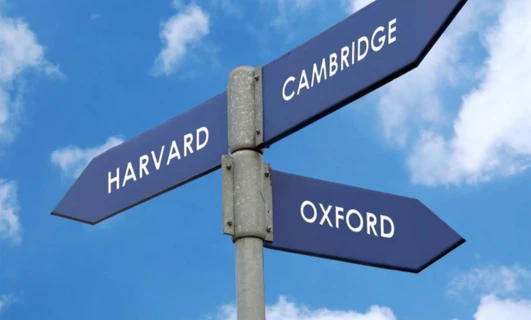 Tablica uliczna w kolorze niebieskim z napisem "HARVARD" w Cambridge. Cambridge Audio prezentuje prestiżowe uniwersytety w nowoczesnym designie.
